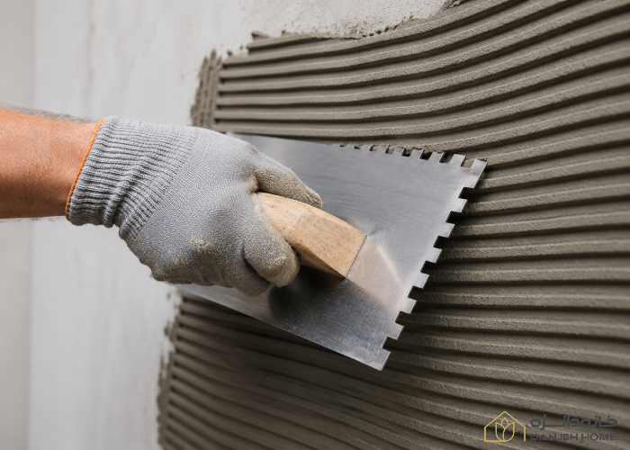 آموزش نصب کاشی: راهنمای صفر تا صد برای اجرای پروژه های حرفه ای نحوه صحیح اعمال چسب کاشی با ماله شانهای.